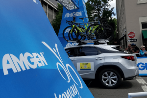 A vehicle carries several bicycles under the starting point for the AMGEN cycling event
